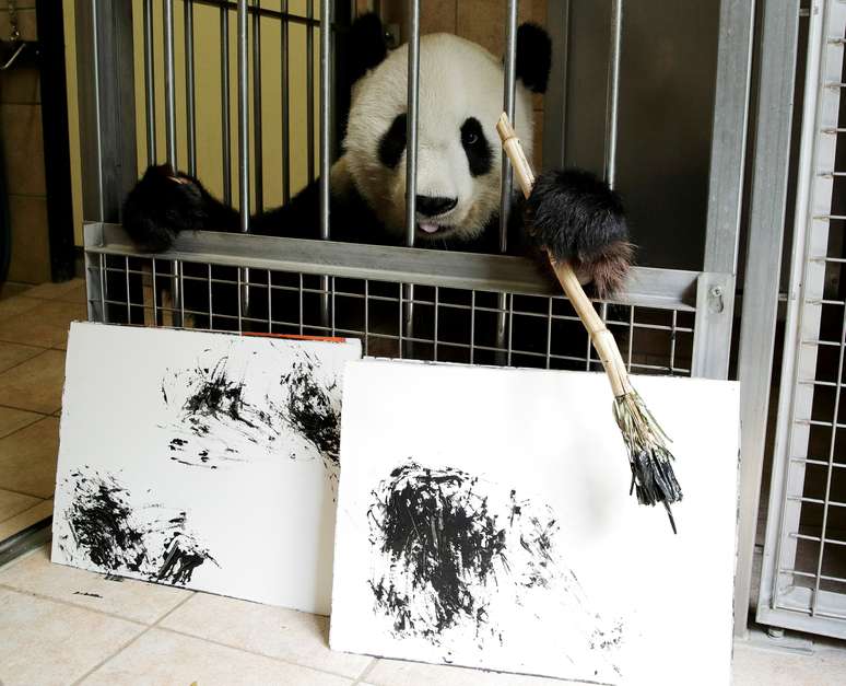 Panda Yang Yang segura pincel atrás de pinturas feitas por ela no zoológico de Viena 10/08/2018 REUTERS/Heinz-Peter Bader