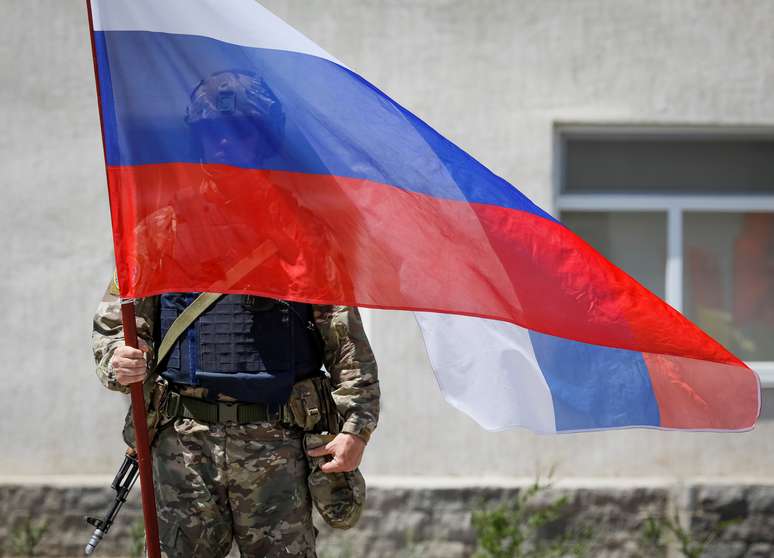 Militar russo segura bandeira do país durante exercício militar