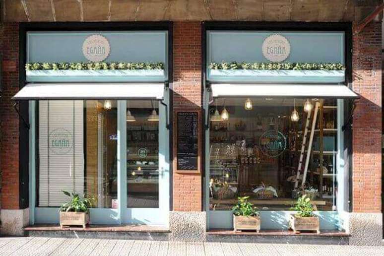 39 &ndash;Fachada de loja tem sobre a porta e a vitrine dois toldos azuis. Fonte: Reciclaprint