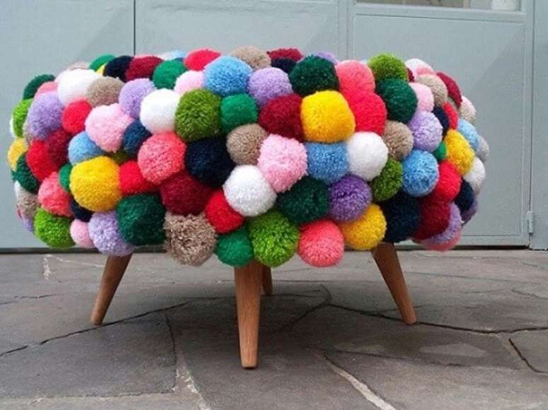 8. Você pode adaptar nosso passo a passo de como fazer puff de pneus cobrindo-o de pompons coloridos. Foto de Pinterest