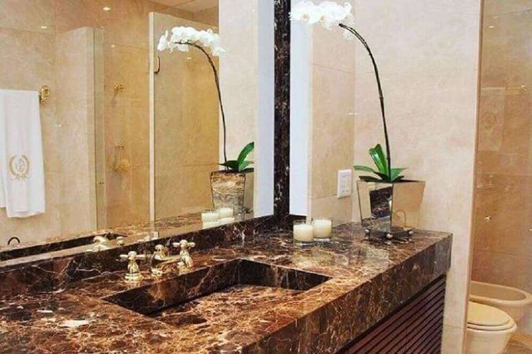 23. Decoração para banheiro com pia moldada em mármore e vaso com orquídeas brancas – Foto: Portela Designer Mármores