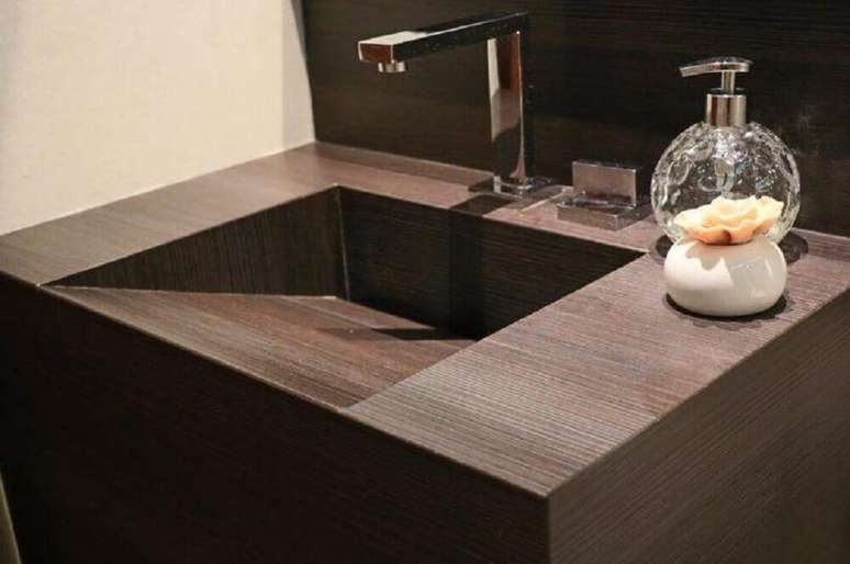 48. Pia esculpida em porcelanato imitando madeira para levar um clima aconchegante ao ambiente decorado &ndash; Foto: Studio M2 Arquitetura