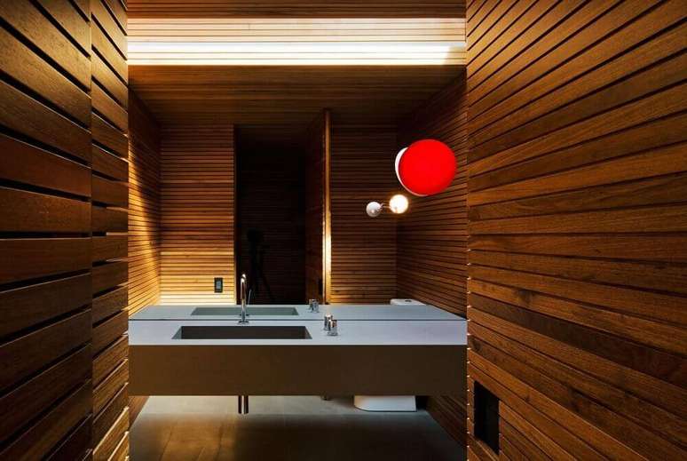 54. Esse com pia esculpida na pedra ganhou um clima agrad&aacute;vel gra&ccedil;as ao revestimento de madeira nas paredes &ndash; Foto: Studio MK27