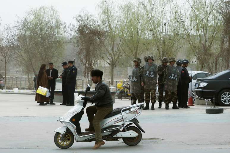 Agentes de polícia checam identidade de pessoas em rua de Kashgar, em Xinjiang 24/03/2017 REUTERS/Thomas Peter
