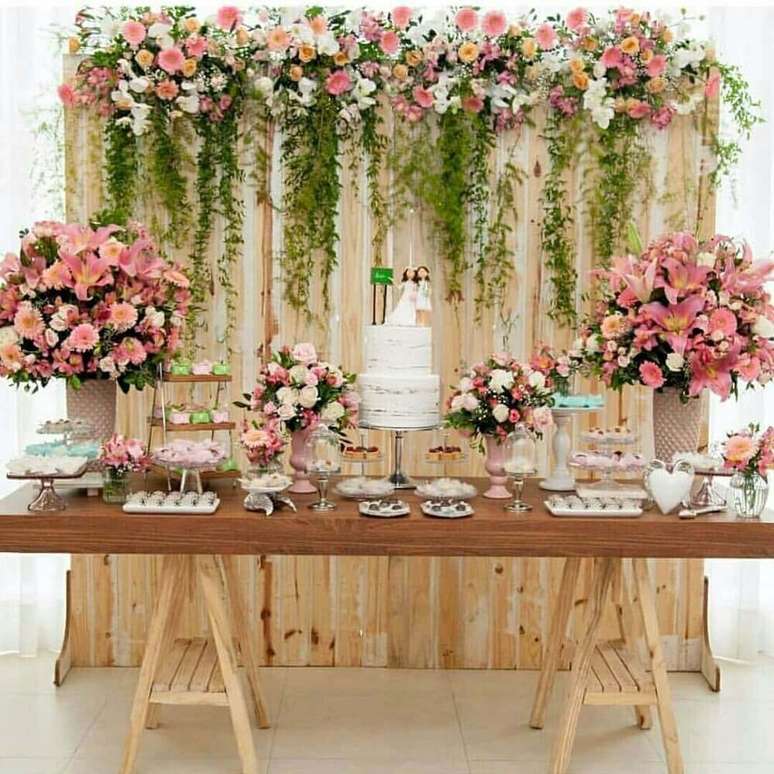 22. Decoração rústica para casamento simples em casa com mesa de madeira e muitos arranjos de flores – Foto: Pinterest