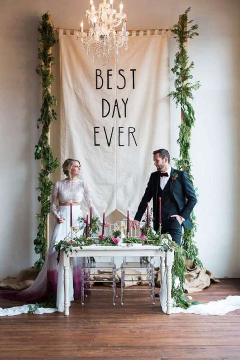 31. Casamento em casa decorado com folhagens e lindo lustre sobre o altar – Foto: Brit + Co