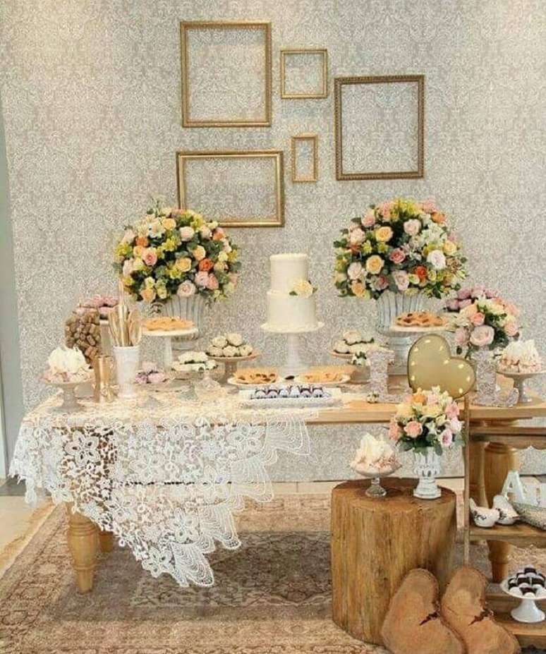 41. Detalhes rústicos e muitas flores para decoração da mesa do bolo de casamento simples em casa – Foto: Point Comunicação