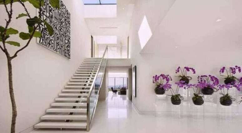 29- Hall de entrada com orqu&iacute;deas lil&aacute;s.