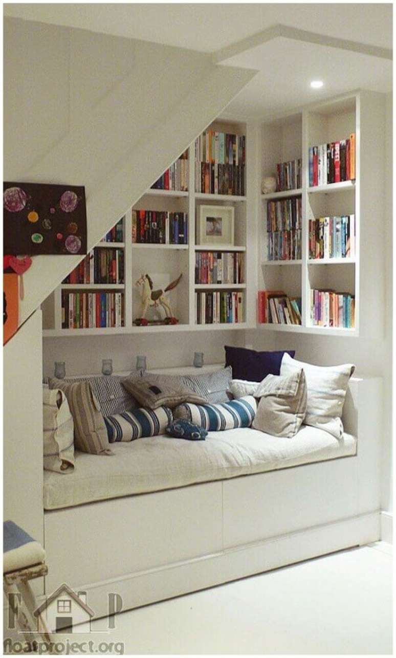 26. O espaço embaixo da escada pode se tornar um charmoso cantinho da leitura – Foto: Tile Design Gallery