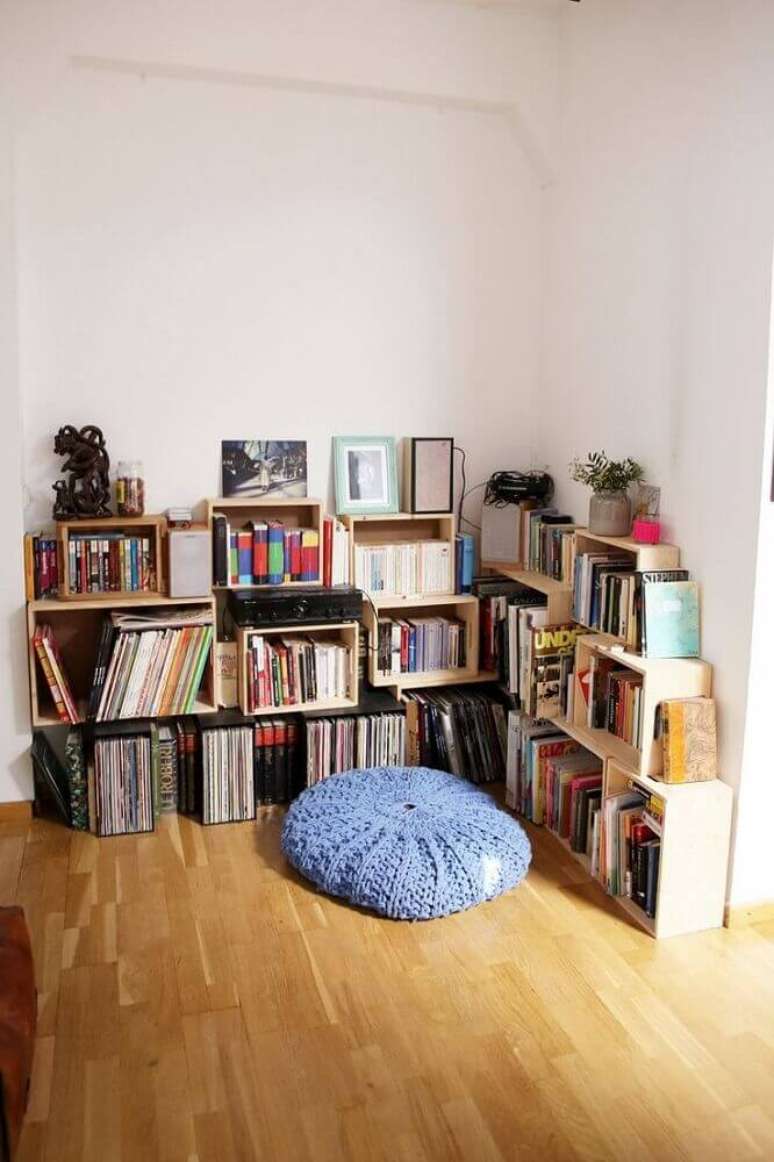32. Decoração para cantinho de leitura simples com almofada redonda e caixotes de madeira para organizar livros – Foto Homedit