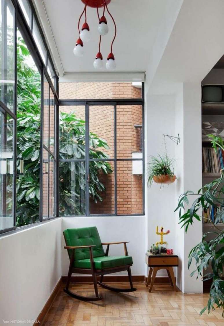 43. Decoração simples para cantinho da leitura na varanda com poltrona de balanço verde e vasos de planta – Foto: Pinterest