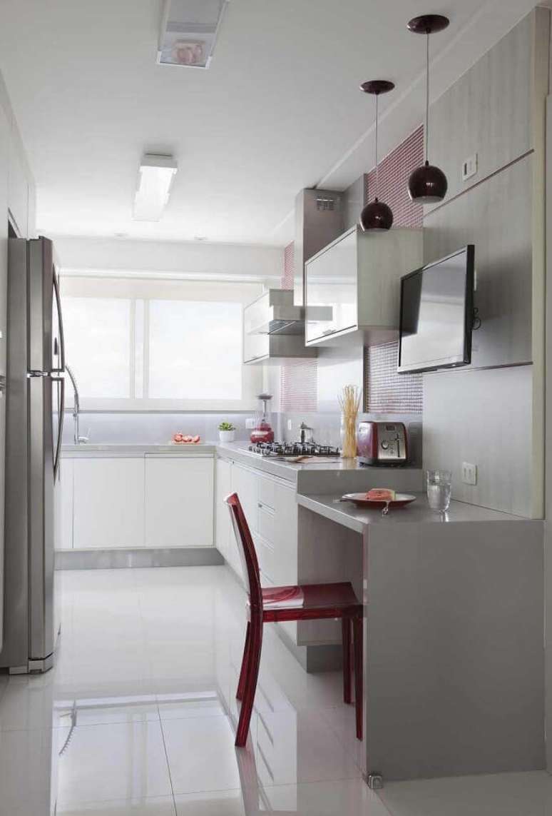 49. A decora&ccedil;&atilde;o clean da cozinha corredor ganhou um toque de cor com pendentes e pastilhas vermelhas nas paredes &ndash; Foto: &Eacute;rica Salguero