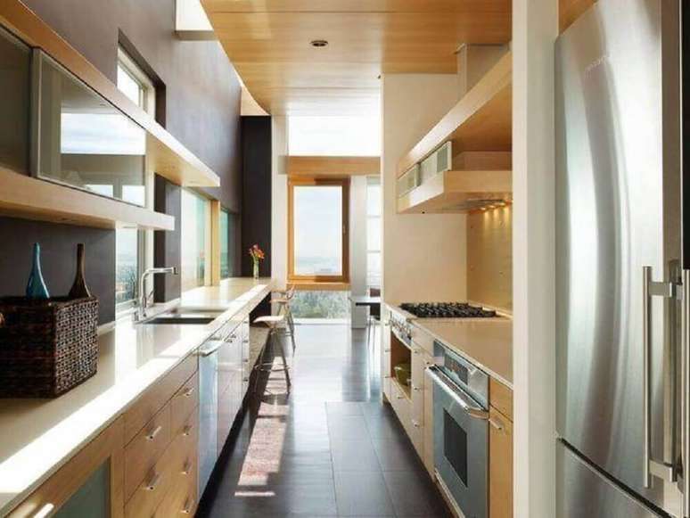 43. Cozinha compacta com pia e prateleiras de madeira e eletrodom&eacute;sticos em inox &ndash; Foto: Debbas Architecture