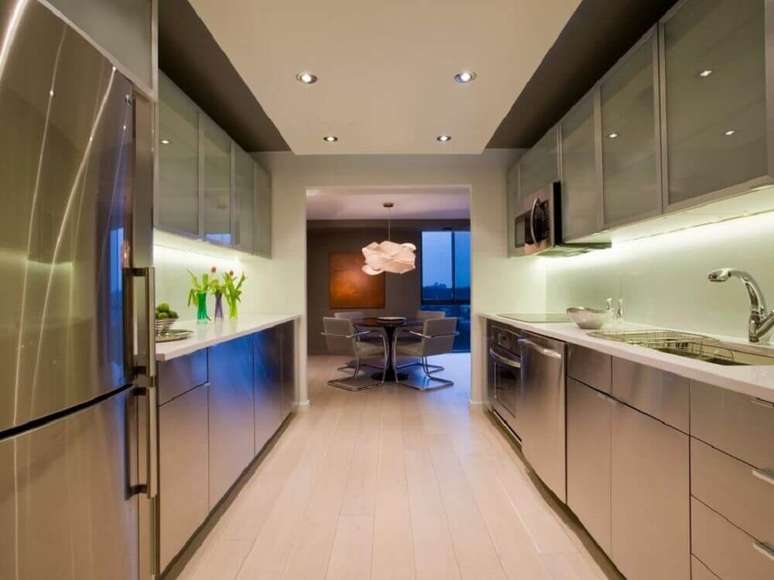 6. Cozinha corredor moderna decorada com eletrodomésticos e armário de cozinha com balcão em inox – Foto: HGTV