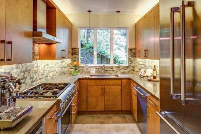 30. Cozinha compacta com armários de madeira planejados – Foto: Jentry McGraw Design Associates
