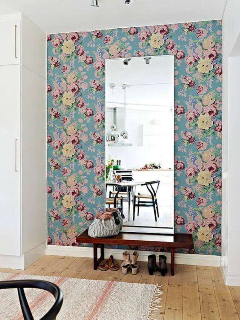 6. A parede do quarto com espelho tem tecido para parede florido charmoso.