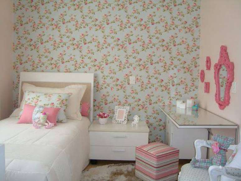 42. O quarto de menina tem tecido para parede e almofadas combinando.