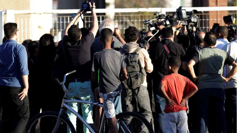 Jornalistas e pedestres observam local em que suspeito de ataque participou de audiência de custódia; candidato do PSL pode ser beneficiado pelo chamado 'efeito de mídia'