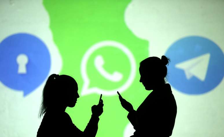Pessoas utilizam celulares diande de projeção dos logos do Signal, WhatsApp e Telegram em foto ilustrativa
28/03/2018 REUTERS/Dado Ruvic