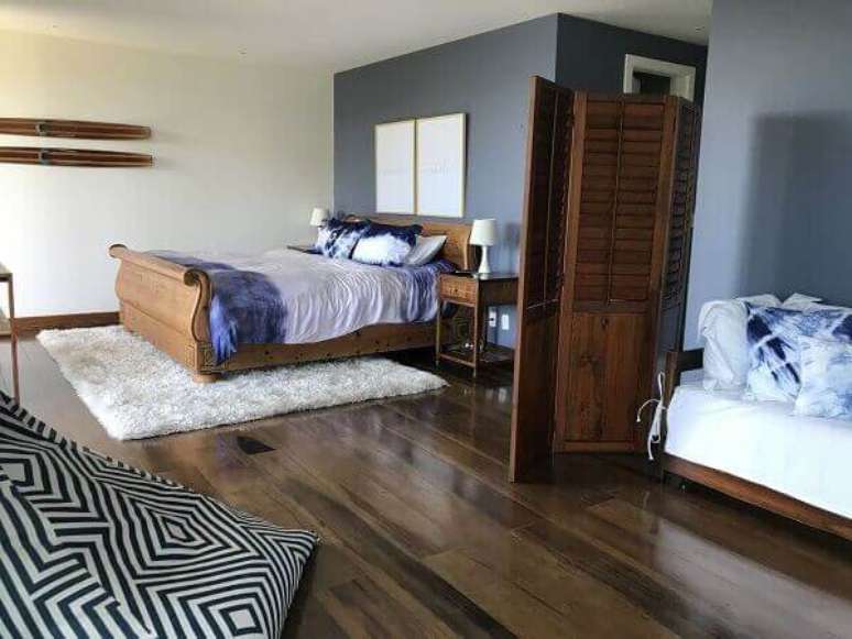 10- O biombo em madeira natural divide o quarto branco em dois ambientes. Fonte: ArqExpress