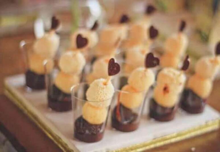 12- A decora&ccedil;&atilde;o de noivado tem docinhos sobre a mesa com palitos decorados com pequenos cora&ccedil;&otilde;es. Fonte: Portais da Moda