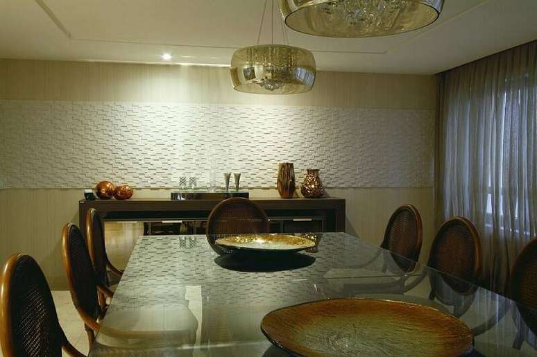 28. Uma faixa de revestimento 3D na sala de jantar traz elegância para o ambiente. Projeto por Celia Beatriz.