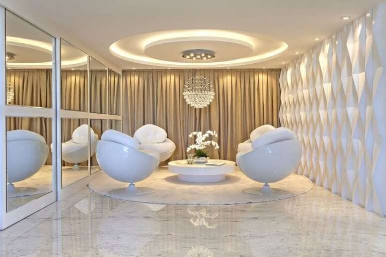 64. Sala de estar clara com parede com revestimento 3D branco. Projeto de Iara Kilaris