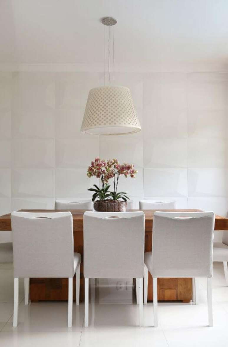 57. Sala de jantar clara com revestimento 3D branco na parede. Projeto de Bianchi Lima