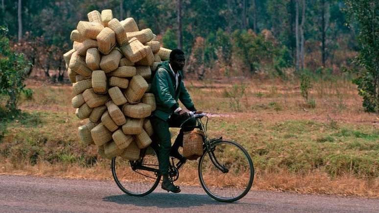 Homem transporta cestas em bicicleta; exercício físico é parte da rotina de muitos ugandenses