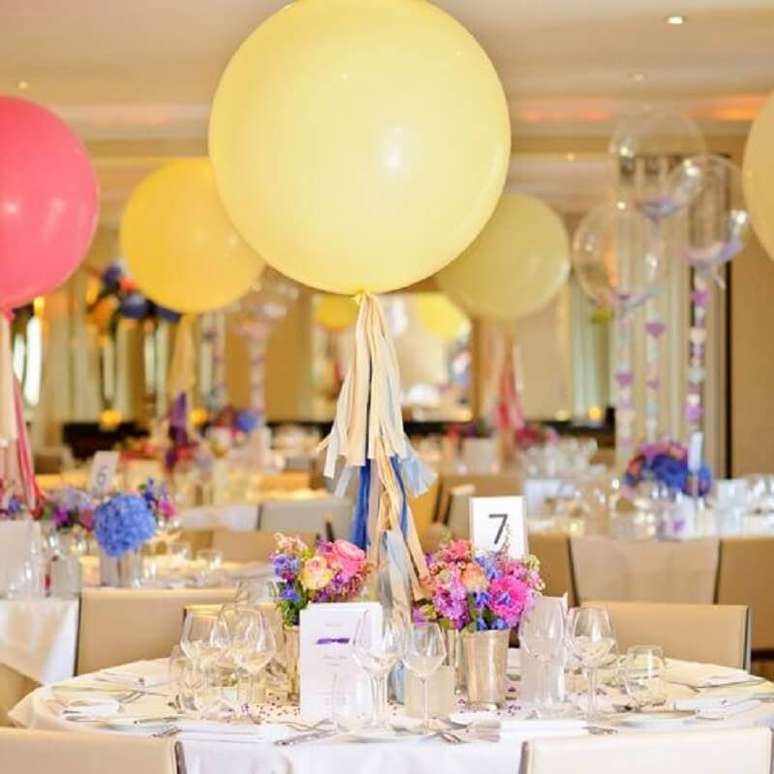 39. Mesa de convidados decorada com pequenos arranjos de flores e balões – Foto: Pinterest