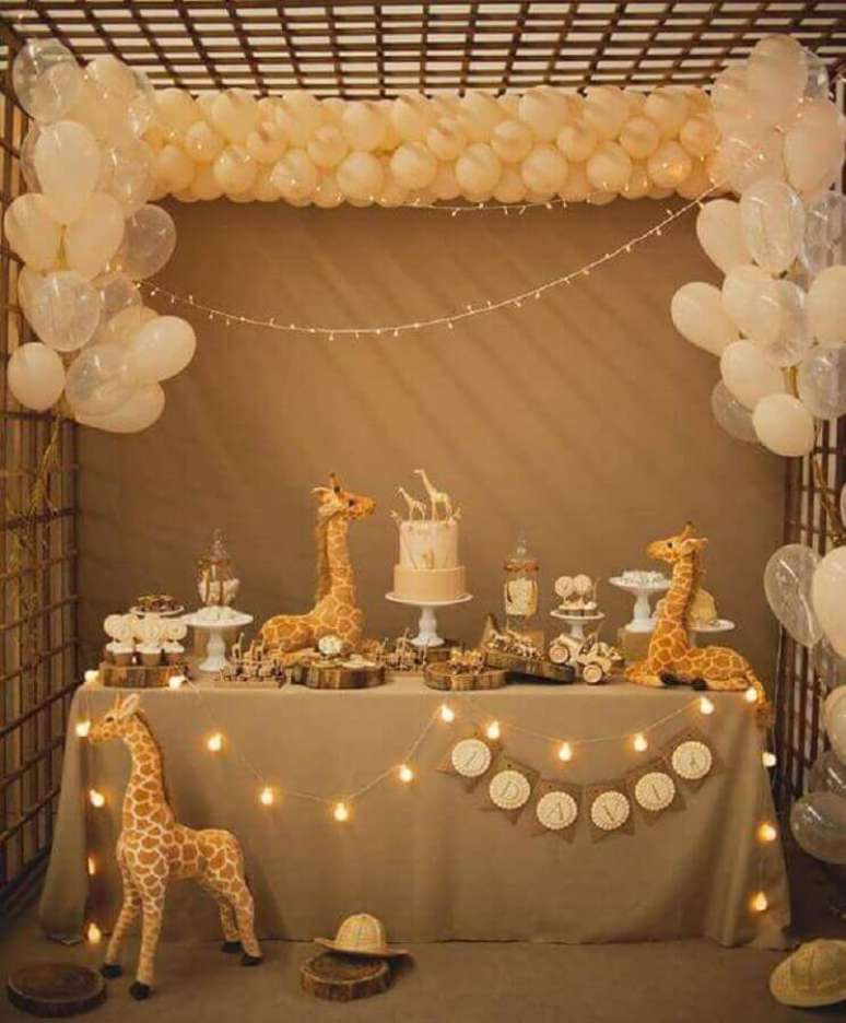 44. Festa infantil decorada com girafas. cordão de luzinhas e painel de balões – Foto: Baby Shower Ideas