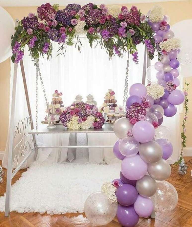 51. Decora&ccedil;&atilde;o com bexigas e arranjos de flores em tons de roxo &ndash; Foto: Celebrations Cake Decorating