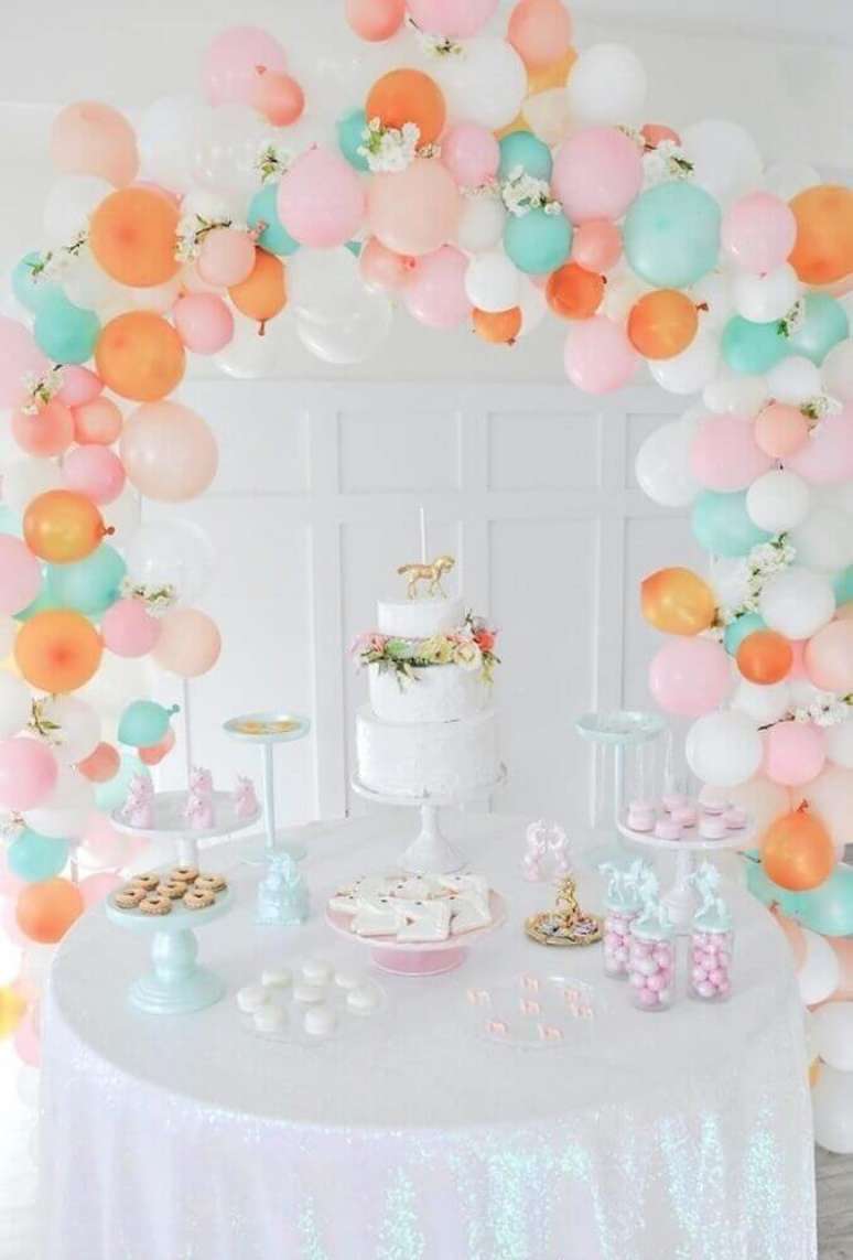 67. Decoração de mesa com balões e bolo branco decorado com arranjo de flores – Foto: Picture Lights