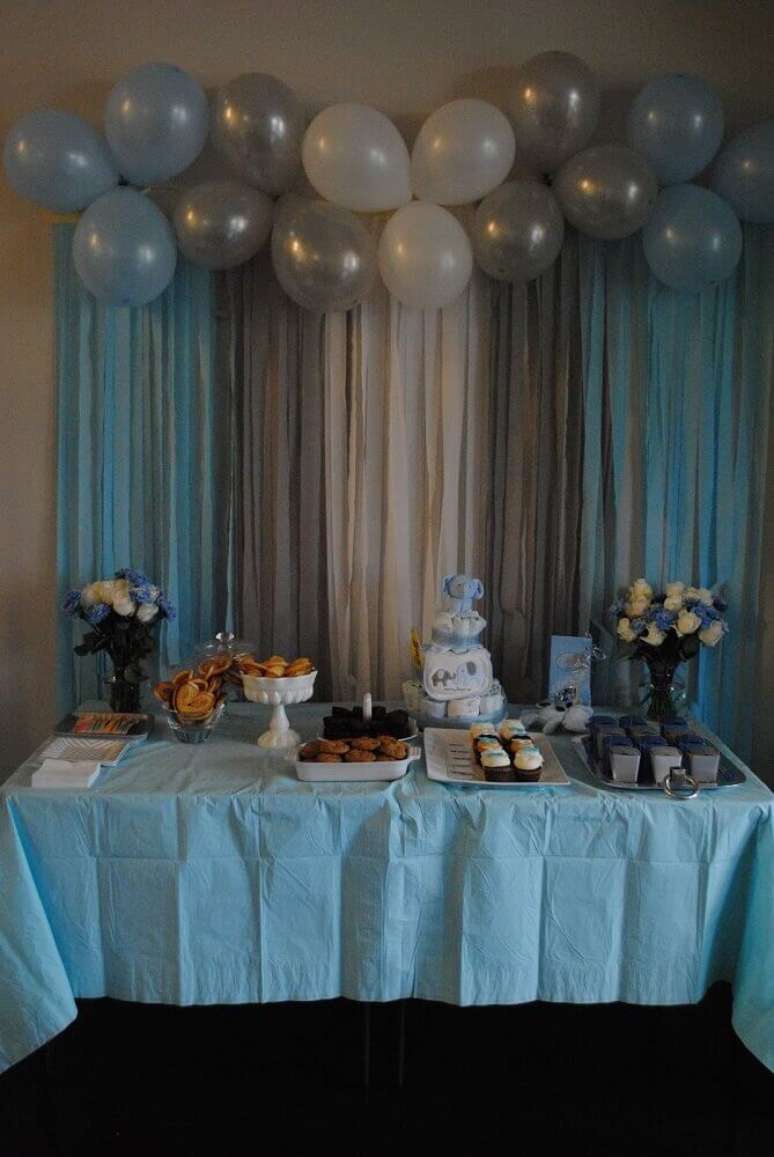 77. Decoração simples com painel de balões e papel crepom para festa em tons de azul – Foto: Walls Ideas