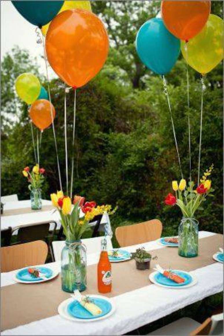 24. Decoração de festa com centros de mesa com potes e bexigas amarradas.