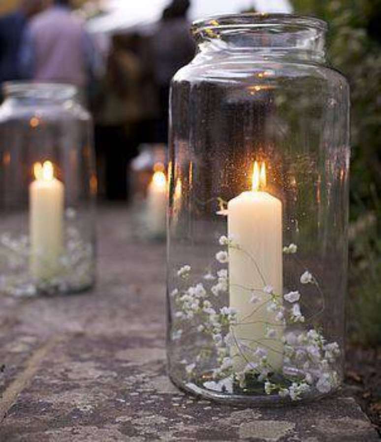50. Os potes com velas e flores delicadas viram lindas lanternais, ideais para festas noturnas.
