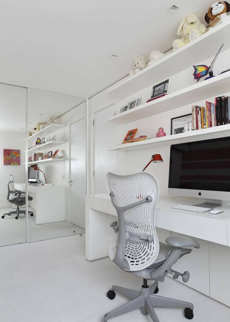 4. Instalar prateleiras próximas à escrivaninha branca ajuda a manter os livros de estudo próximos. Projeto por Izabela Lessa.