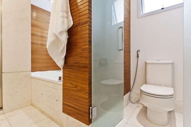 29. Sala de banho com revestimento de madeira e bacia com caixa acoplada. Foto de Sesso e Dalanezi