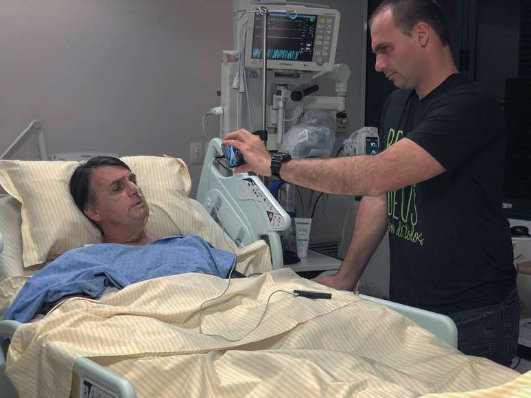 Jair Bolsonaro no quarto do hospital Albert Einstein, em São Paulo, ao lado do filho, Eduardo