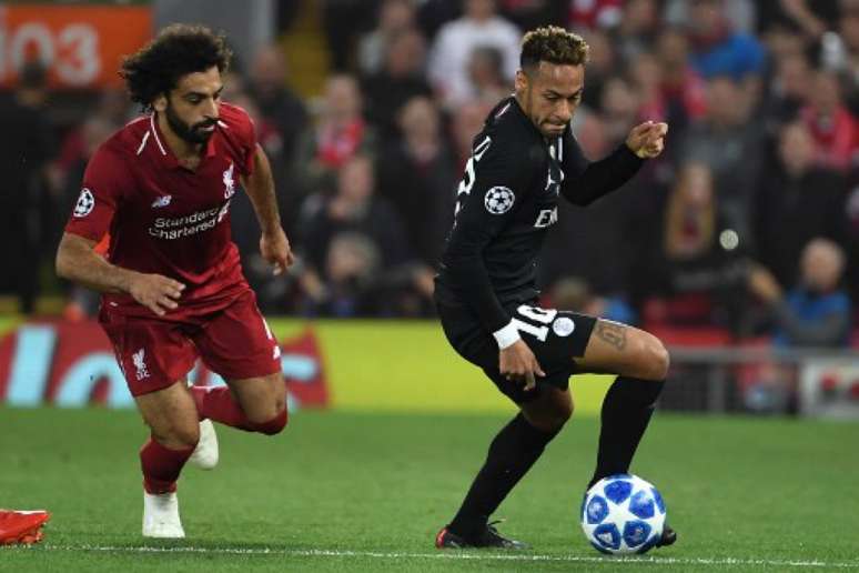 Neymar recebe a marcação de Salah no duelo entre Liverpool e PSG (Paul Ellis / AFP)