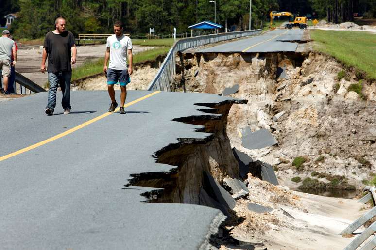 Moradores caminham em estrada destruída por furacão Florence na Carolina do Norte
 19/9/2018    REUTERS/Jonathan Drake 