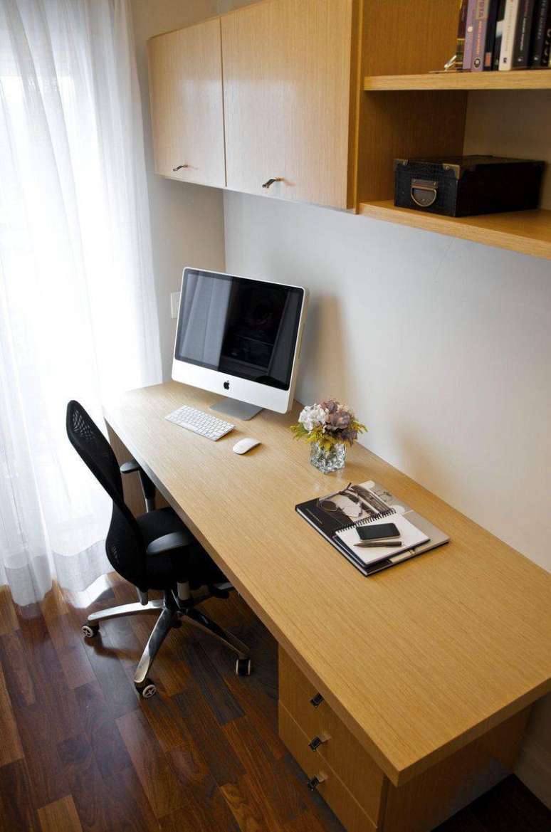 5. Essa escrivaninha para quarto clássica de madeira possui gavetas inclusas na mesa. Projeto de Danyela Correa