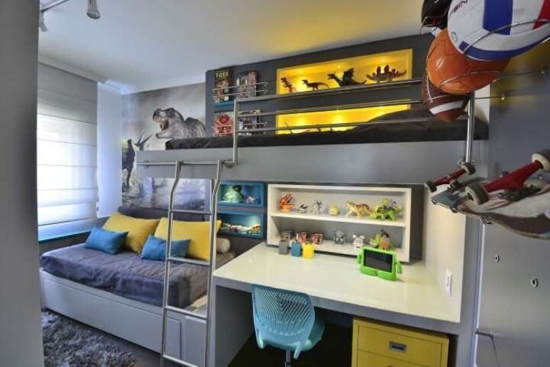 40. Escrivaninha integrada à cama suspensa em quarto com decoração de dinossauro. Projeto de BG Arquitetura