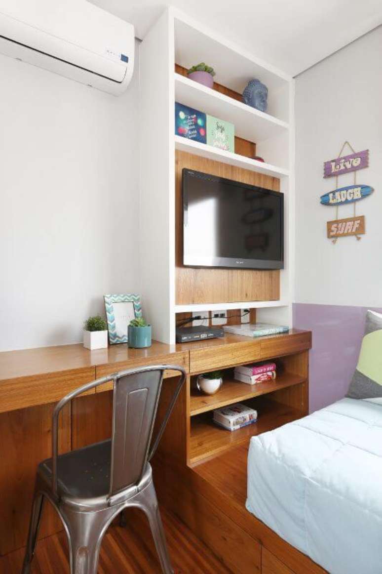 46. Escrivaninha para quarto de madeira embutida na decora&ccedil;&atilde;o com cadeira industrial contrastando. Projeto de Bianchi Lima