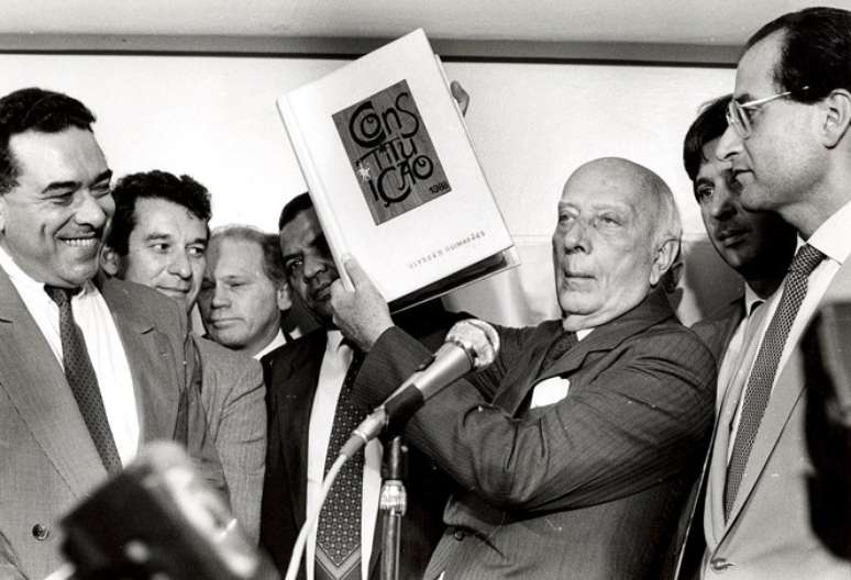 Ulysses Guimarães mostra a Constituição brasileira, promulgada em 1988
