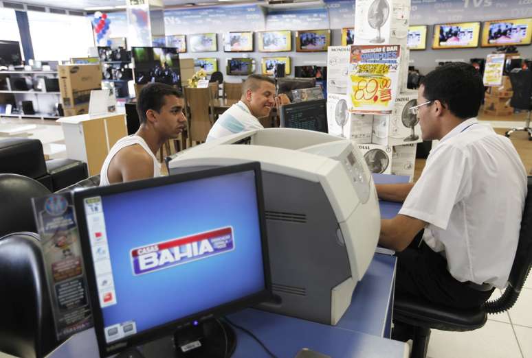 Clientes conversam com atendente de vendas da Casas Bahia, bandeira da Via Varejo. 18/02/2013. REUTERS/ Nacho Doce.