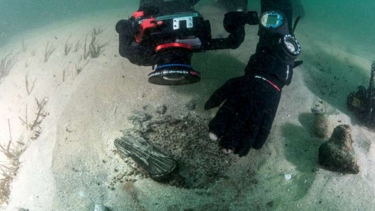 Imagem mostra mergulhador registrando imagens de objetos encontrados nas proximidades de embarca&ccedil;&atilde;o que naufragou h&aacute; 400 anos em Portugal