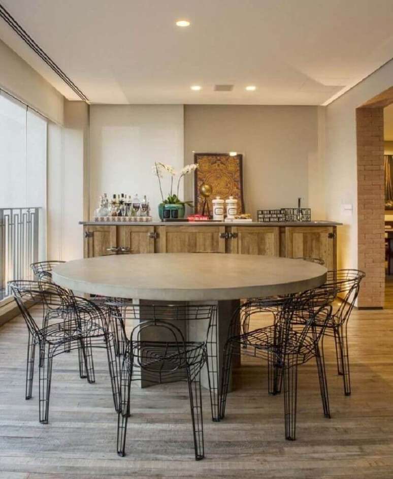 12. Decoração para varanda com buffet de madeira e mesa redonda com cadeiras modernas – Foto: Triplex Arquitetura