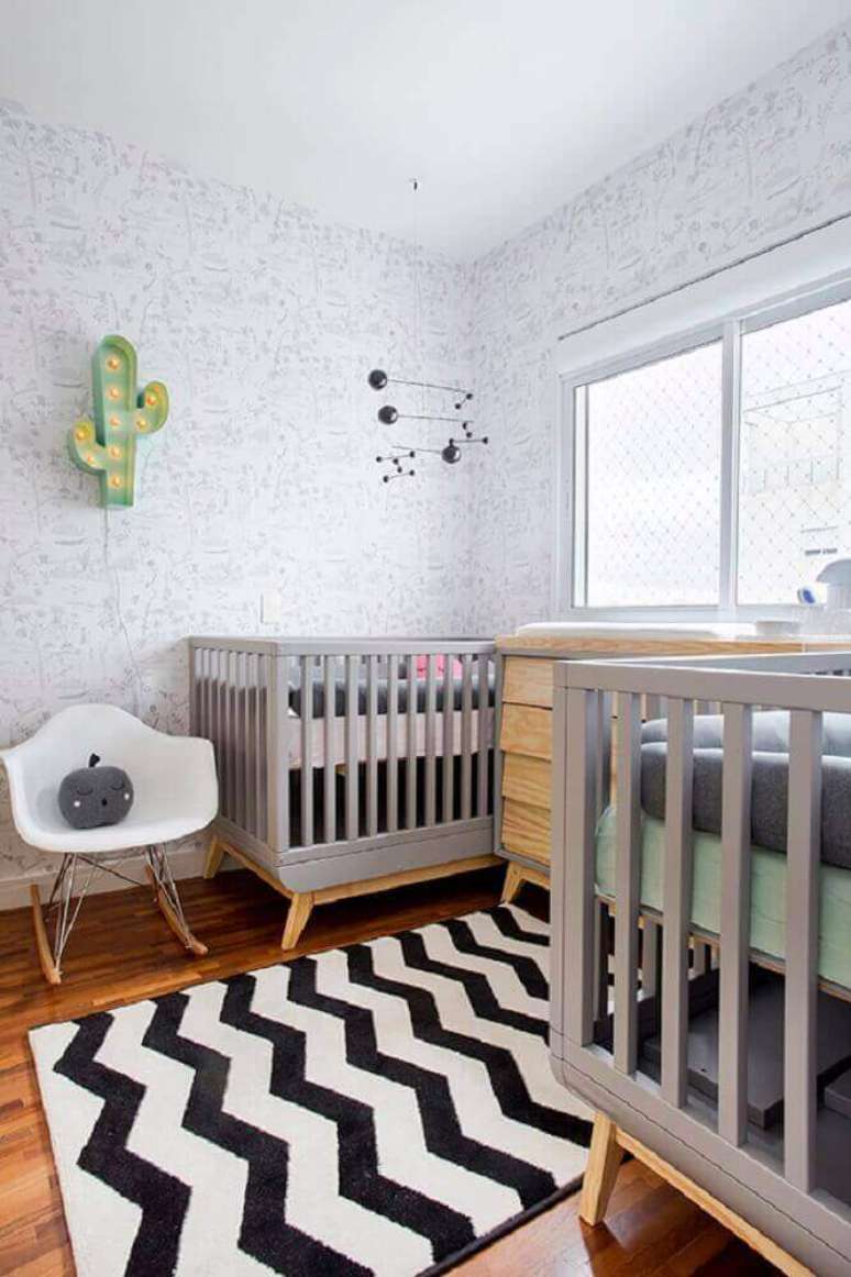 15. Cadeira de amamentação moderna para quarto de bebê decorado com tapete preto e branco e luminária em formato de cacto – Foto: Pinterest