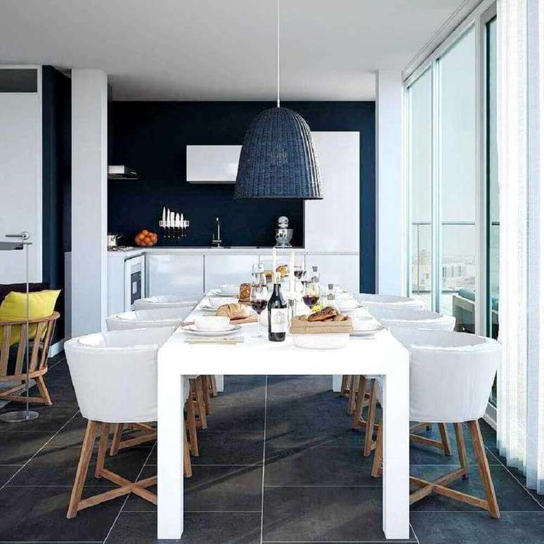 39. Cadeiras para sala de jantar modernas decoradas em tons de branco e azul escuro com pendente grande sobre a mesa de jantar branca – Foto: InMyRoom